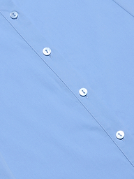 Close-up of the Maurie Poplin Maxi Dress in light blue organic cotton-blend fabric, showing four white buttons and stitched buttonholes along the front. The dress is neatly pressed and laid flat.