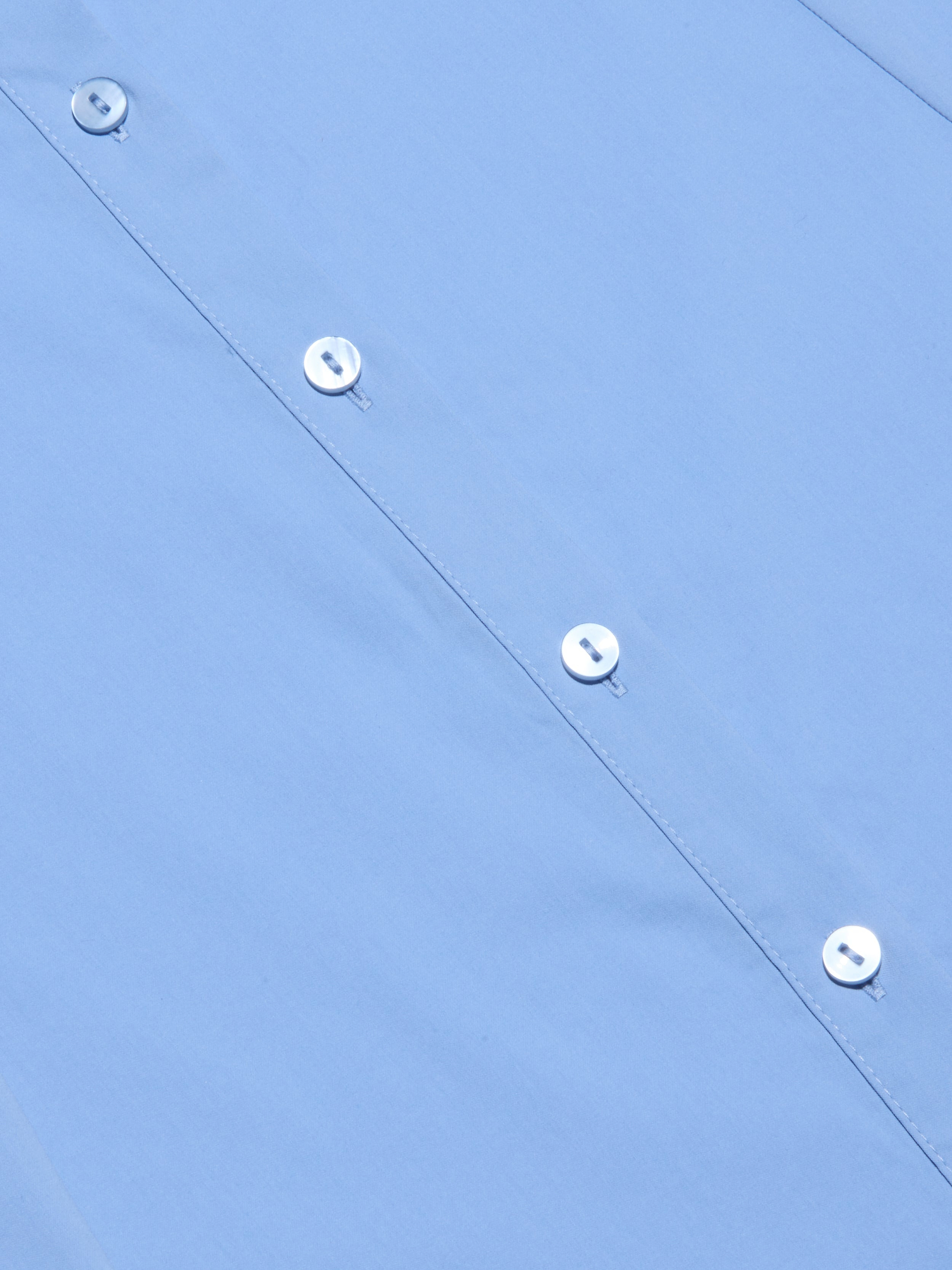 Close-up of the Maurie Poplin Maxi Dress in light blue organic cotton-blend fabric, showing four white buttons and stitched buttonholes along the front. The dress is neatly pressed and laid flat.
