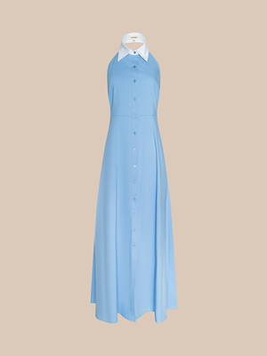 The Maurie Poplin Maxi Dress in sleeveless light blue organic cotton poplin features a button-front, flared skirt, and contrasting white pointed collar, shown against a plain beige background.