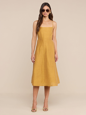 Una donna posa su uno sfondo neutro con il Meredith Linen-Blend Dress, un modello giallo senape senza maniche con scollatura quadrata. La donna indossa occhiali da sole, orecchini a cerchio e tacchi aperti per un elegante look estivo.