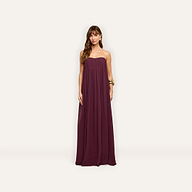 A woman models the floor-length, plum-colored Raine Strapless Gown, which features a strapless, pleated bodice made of viscose chiffon.