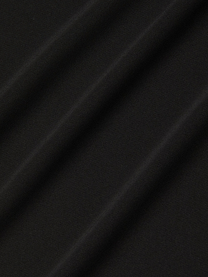 Close-up of the Raye Slip Lining Dress in smooth, black stretch jersey fabric, featuring diagonal folds that form soft, shadowed ridges on the sleek, slightly matte surface.