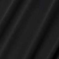 Close-up of the Raye Slip Lining Dress in black poly georgette fabric, featuring subtle diagonal folds that highlight its smooth texture and slight sheen under the light.