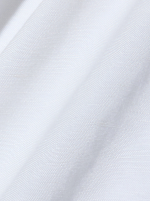Primo piano del morbido tessuto bianco dellAmora Pearl Strap Dress, caratterizzato da sottili pieghe che ne evidenziano il design elegante e minimalista, perfetto per un look sofisticato e senza tempo.