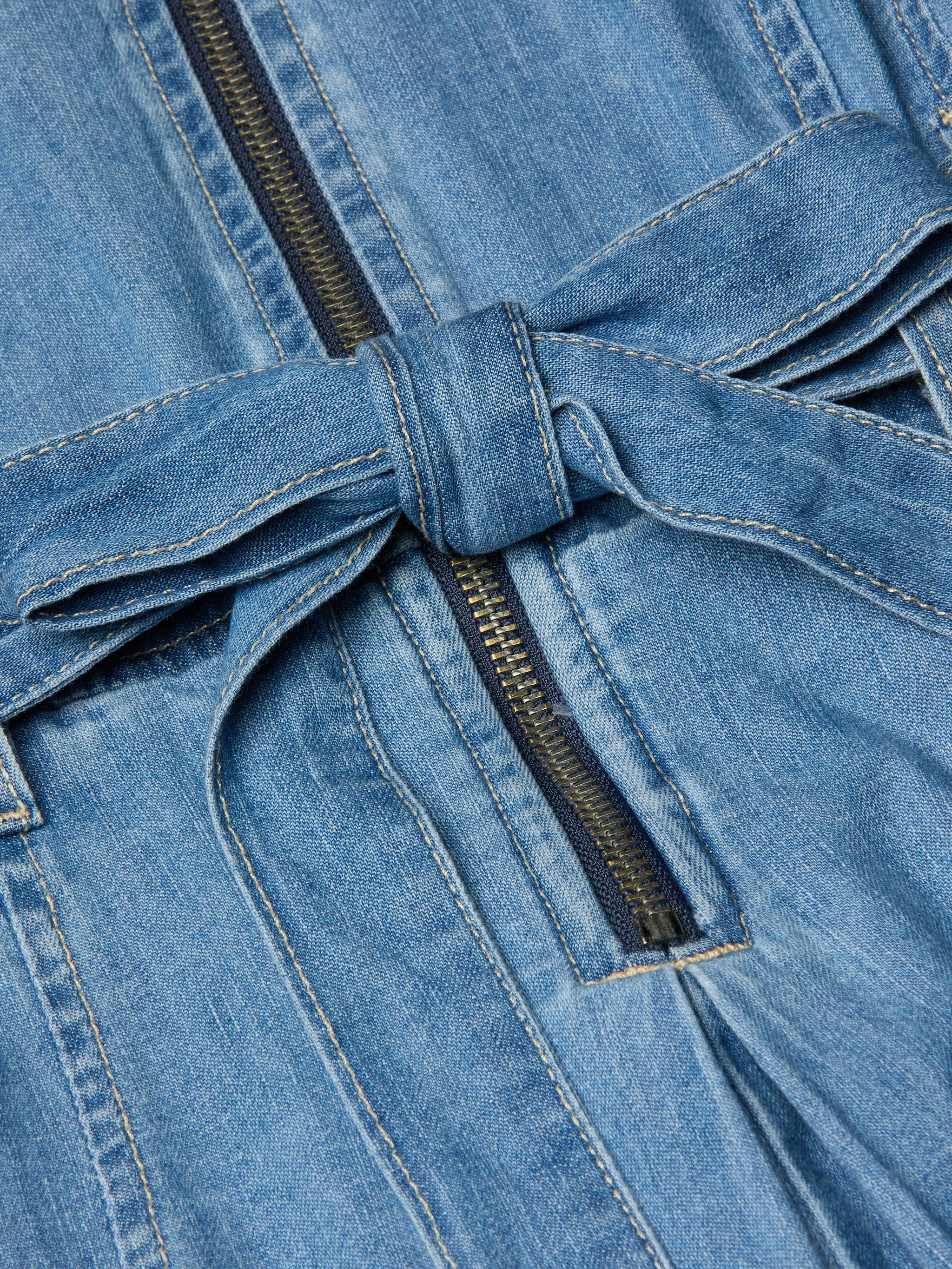 Close-up of the Kieran Shirt Dress in blue featherweight denim, showcasing a tie belt and a visible black zipper running vertically down the center.