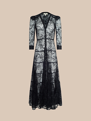 The Seraphina Lace Tiered Maxi Dress showcases a long, sheer lace design with three-quarter sleeves, V-neckline, button-down front, and fitted waist, all set against a beige background for an elegant look.