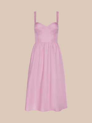 The Tiani Bustier Dress is a sleeveless, light pink summer dress with underwire cups, wide straps, and a fitted bodice. It features a gathered knee-length skirt and is displayed on a plain beige background.