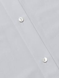 Close-up of the Ridley Shirt Dress, showcasing the organic cotton fabric’s texture, meticulous stitching, and two white buttons along the button placket for a soft, comfortable feel.