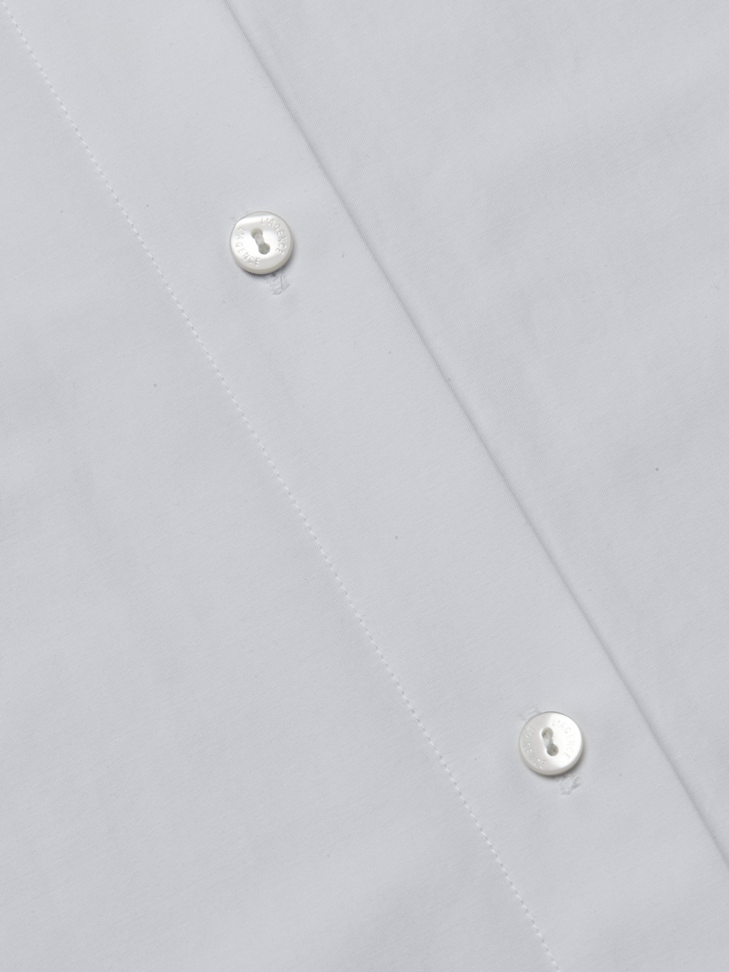 Close-up of the Ridley Shirt Dress, showcasing the organic cotton fabric’s texture, meticulous stitching, and two white buttons along the button placket for a soft, comfortable feel.