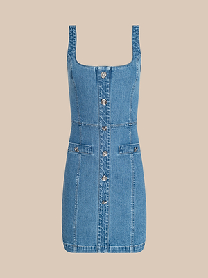 La robe Vynna de LAGENCE est une robe sans manches en denim extensible bleu, avec une encolure carrée, une fermeture boutonnée sur le devant et deux poches sur le devant, sur un fond beige clair.