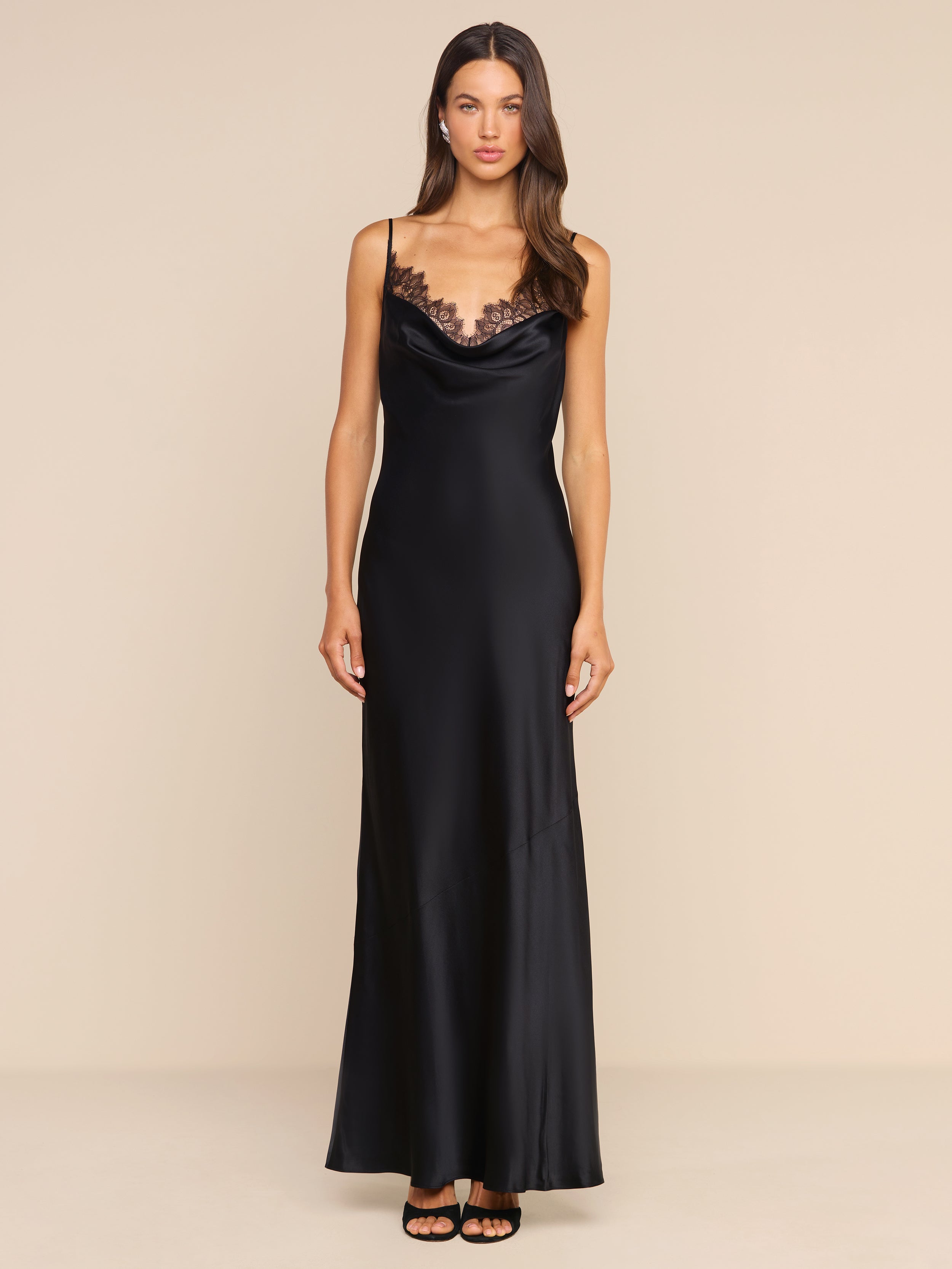A woman stands against a plain white background wearing the Selene Silk Gown, featuring Chantilly lace trim, paired with black heels.