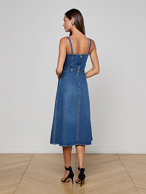 A woman wearing the Jovie Bustier Dress, featuring a blue denim A-line skirt.