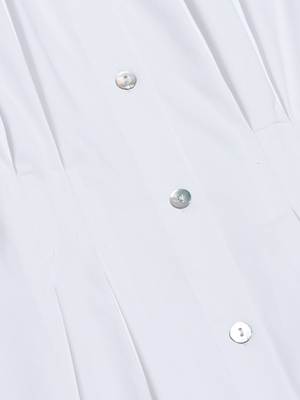 Close-up of the Journi Shirt Dress in white stretch poplin featuring metallic buttons, visible seams, and pleats along the placket for a timeless silhouette.