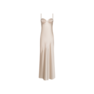 The Sayla Silk Gown is a long, sleeveless champagne-hued silk dress featuring delicate spaghetti straps and a fitted, structured bodice that channels vintage glamour, elegantly showcased against a plain white background.