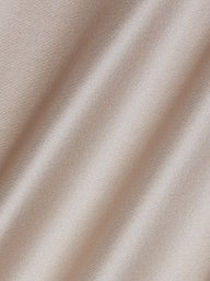 Close-up of the Sayla Silk Gown’s pale champagne-colored satin fabric, featuring soft diagonal folds and a smooth, shiny, and reflective texture that evokes the elegance of vintage glamour.