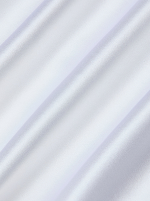 Close-up of the Sayla Silk Gown’s smooth, shiny white fabric with soft folds, evoking vintage glamour as gentle diagonal shadows and highlights play across its luxurious silk surface.
