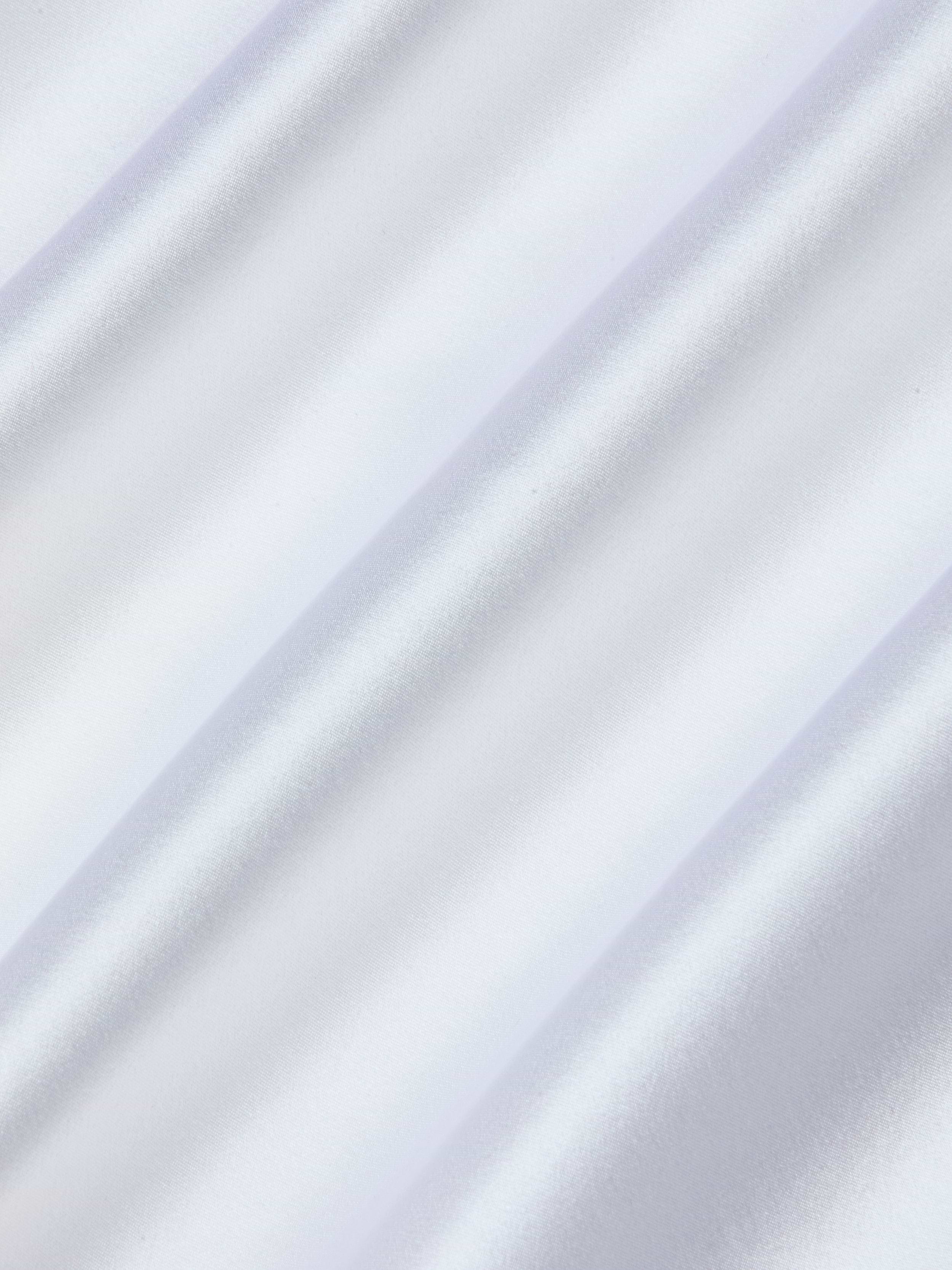 Close-up view of pale, silvery-white satin fabric with soft, diagonal folds creating subtle shadows and a glossy, reflective surface—perfect for the Sayla Silk Gown, capturing vintage glamour.