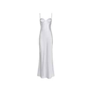 The Sayla Silk Gown, displayed on a plain white background, is a white, floor-length dress crafted from lustrous silk with thin spaghetti straps and a fitted bustier-style bodice that channels vintage glamour, making it an event-ready choice.