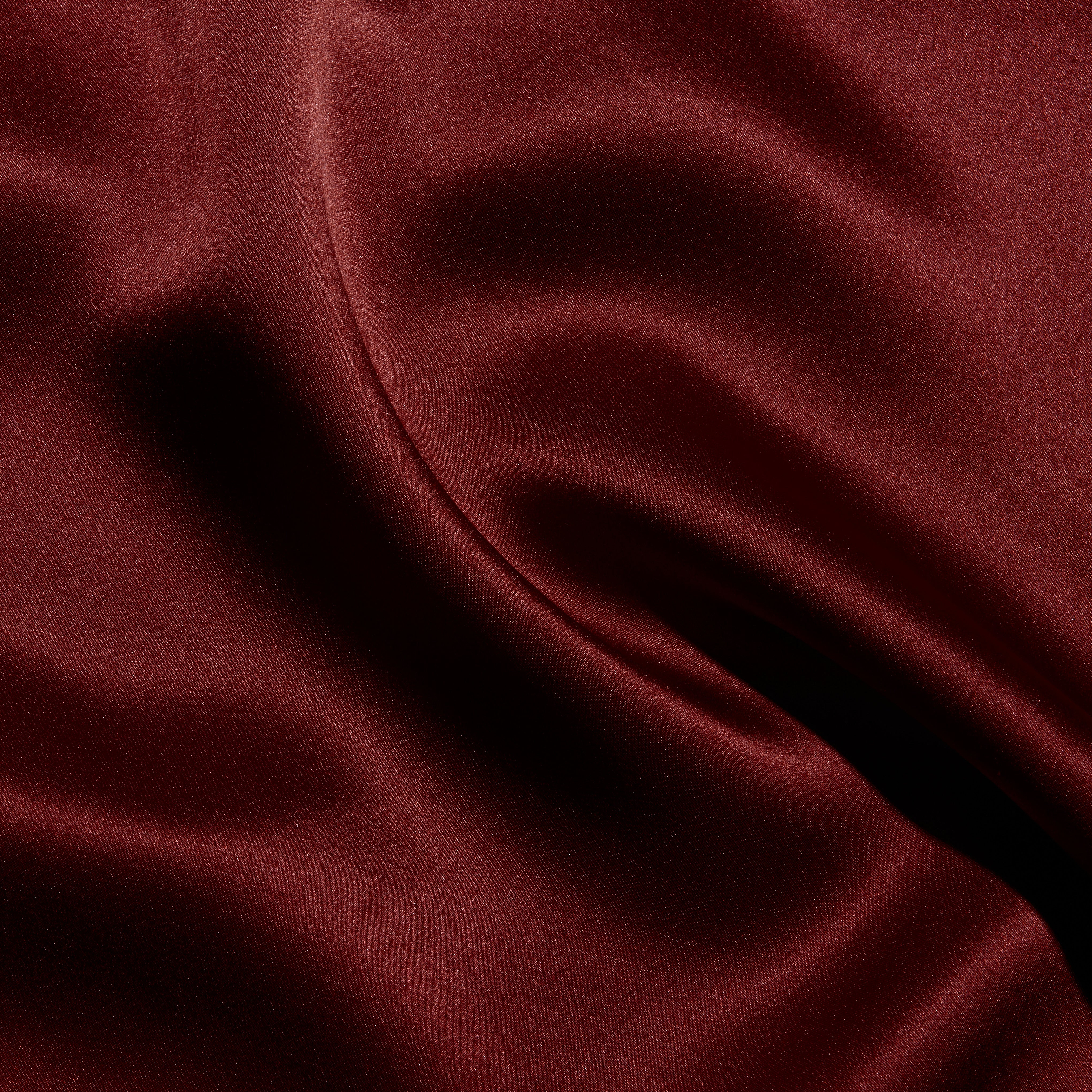 Deep red silk fabric of the Sayla Silk Gown draped in soft folds with vintage glamour.