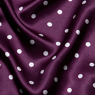 Sayla Silk Gown crafted from purple satin adorned with white polka dots, featuring gentle folds and a soft, smooth texture—perfect for a vintage glamour look or an event-ready dress.