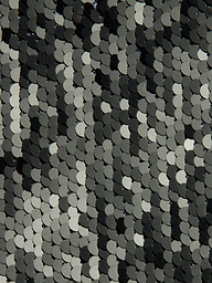 Gros plan sur les paillettes noires, blanches et argentées de la robe Sayla Sequin Gown, disposées de manière à se chevaucher, créant ainsi un look chatoyant dinspiration vintage.