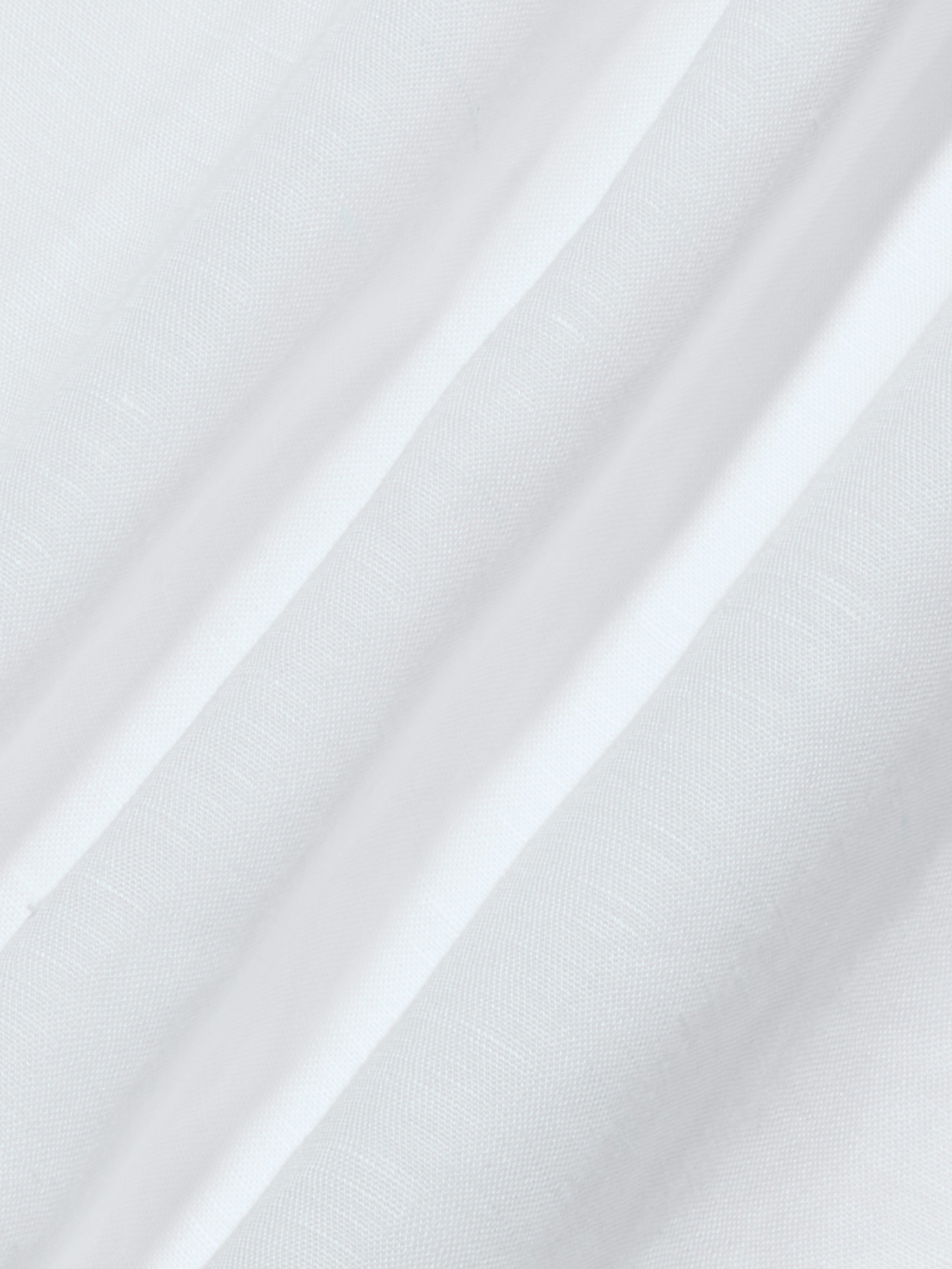 The Didi Maxi Dress features a white linen-blend fabric with subtle vertical stripes, showcasing a smooth texture and delicate weave pattern. The gentle folds are highlighted by the lighting, enhancing the softness of the material—perfectly suited for a maxi dress.