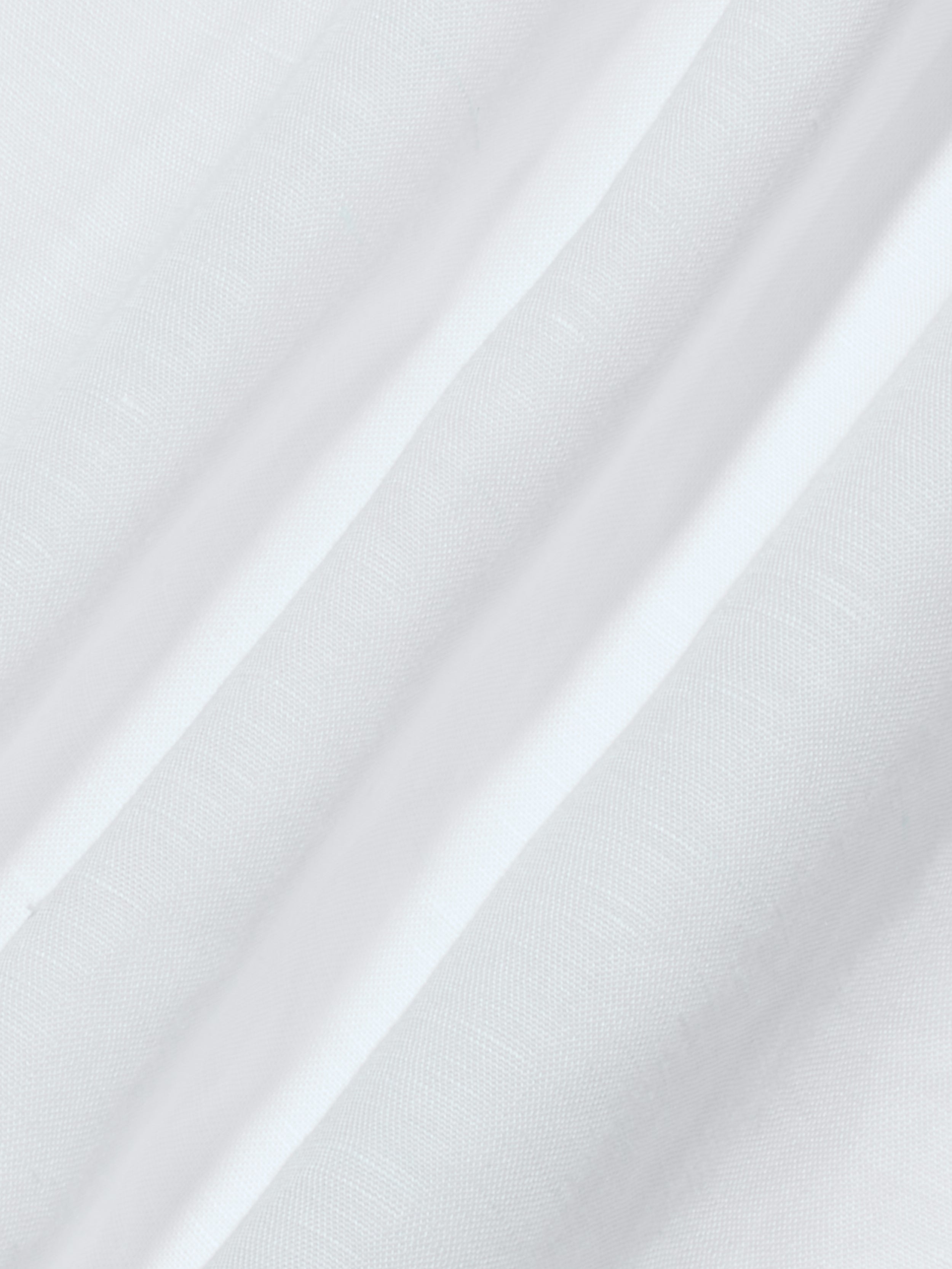 The Didi Maxi Dress features a white linen-blend fabric with subtle vertical stripes, showcasing a smooth texture and delicate weave pattern. The gentle folds are highlighted by the lighting, enhancing the softness of the material—perfectly suited for a maxi dress.