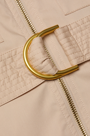 Close-up of the Callen Shirt Dress in beige stretch cotton-blend, featuring an exposed front zipper and a matching belt with a shiny gold D-ring buckle. The stitching and fabric texture are clearly visible.