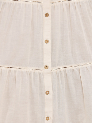 Close-up of the Serafine Midi Dress in cream, crafted from lightweight voile with a vertical row of small beige buttons and delicate stitching—ideal for summer wear or elevating your elegant wardrobe.