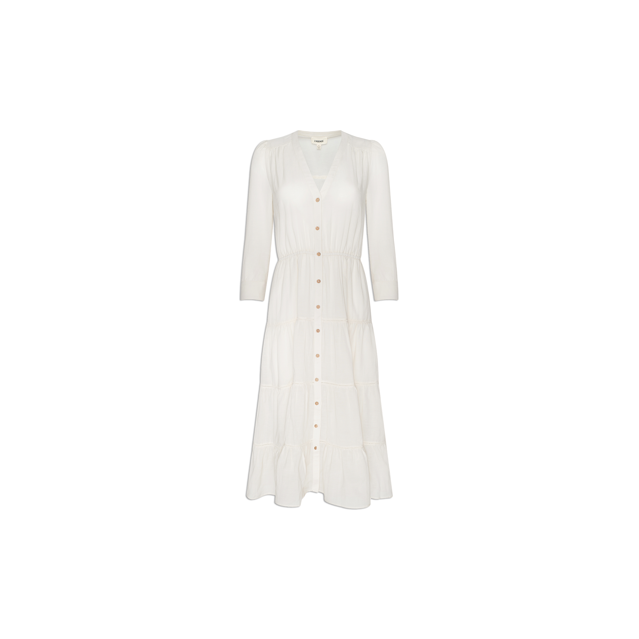 The Serafine Midi Dress, shown on a plain white background, is a white, long-sleeve midi dress featuring a v-neckline, button-down front, and a slightly gathered waist. Made from lightweight voile, this dress is perfect for warm weather.