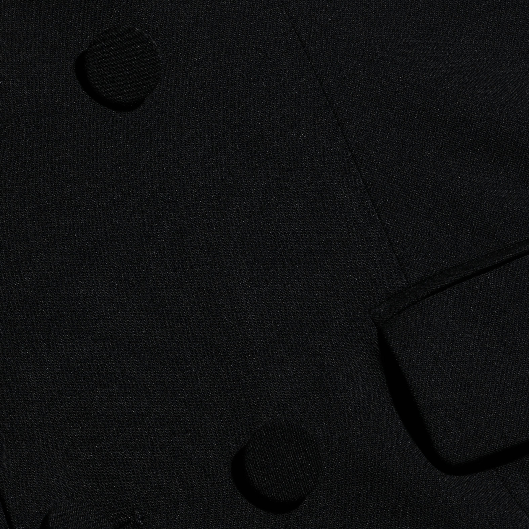Vale Tuxedo Dress, a black maxi dress styled like a tuxedo jacket with fabric-covered buttons and a flap pocket.