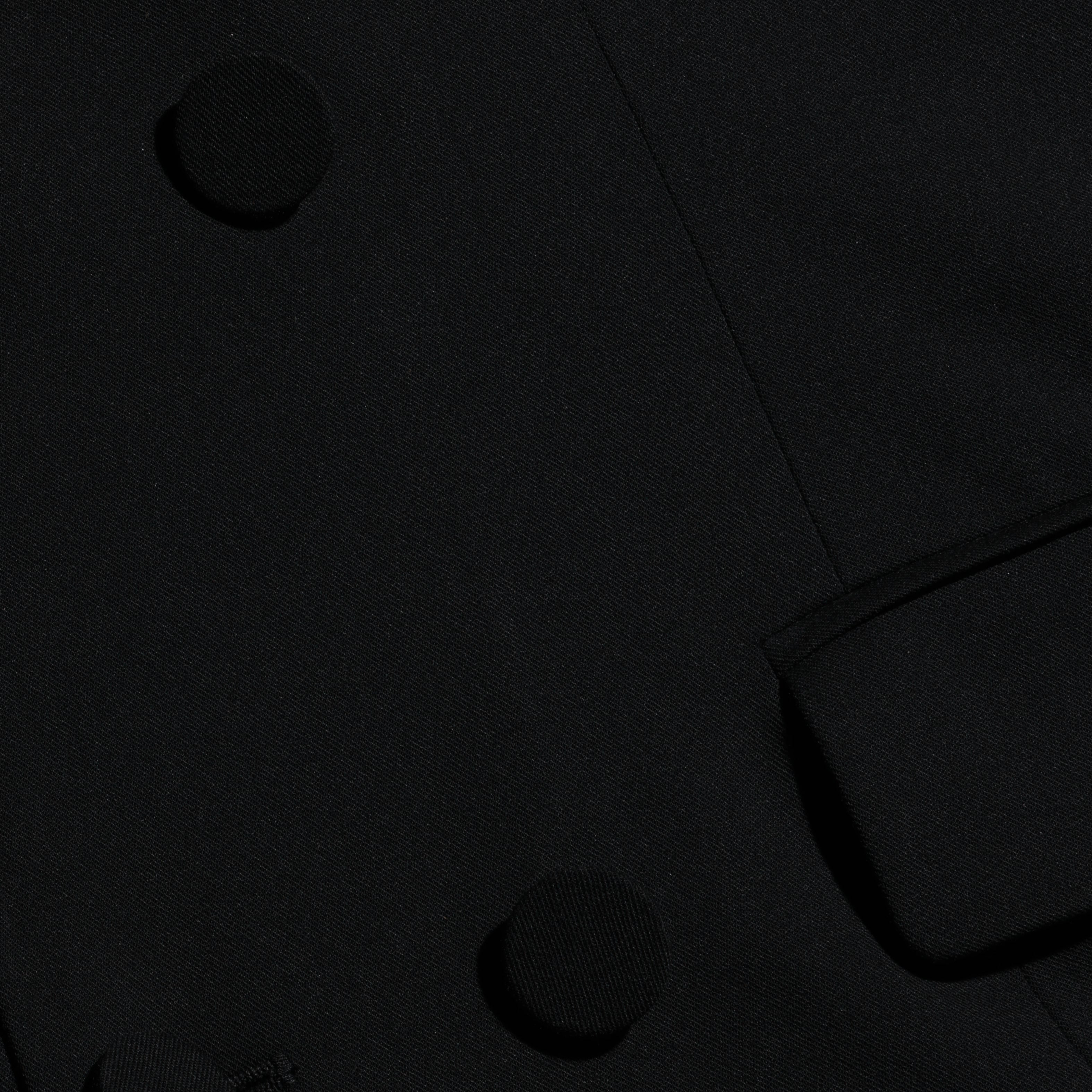 Vale Tuxedo Dress, a black maxi dress styled like a tuxedo jacket with fabric-covered buttons and a flap pocket.