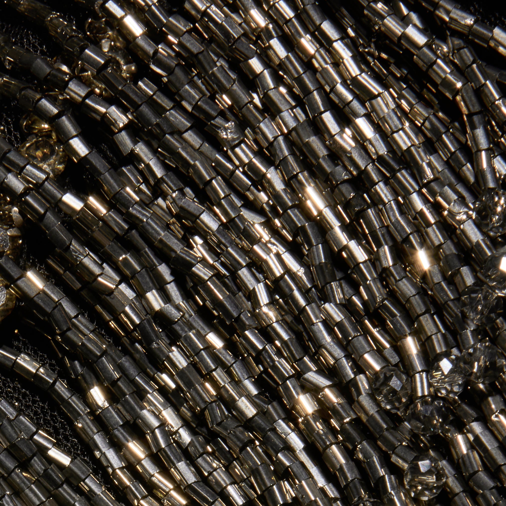 Close-up of rows of metallic dark gray beaded fringe on the halter neckline of the Niobe Fringe Dress.