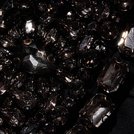 Close-up of black faceted crystals and teardrop-shaped stones sewn onto the satin fabric of a Yuan Embellished Gown.