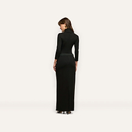 A person viewed from behind wearing a black, long-sleeved Jaesyn Dress that falls to the floor.