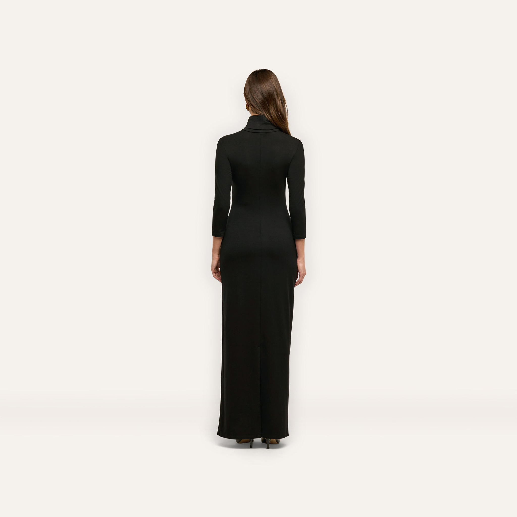 Back view of a woman wearing the black, jersey knit Jaesyn Dress with a turtleneck and three-quarter length sleeves.