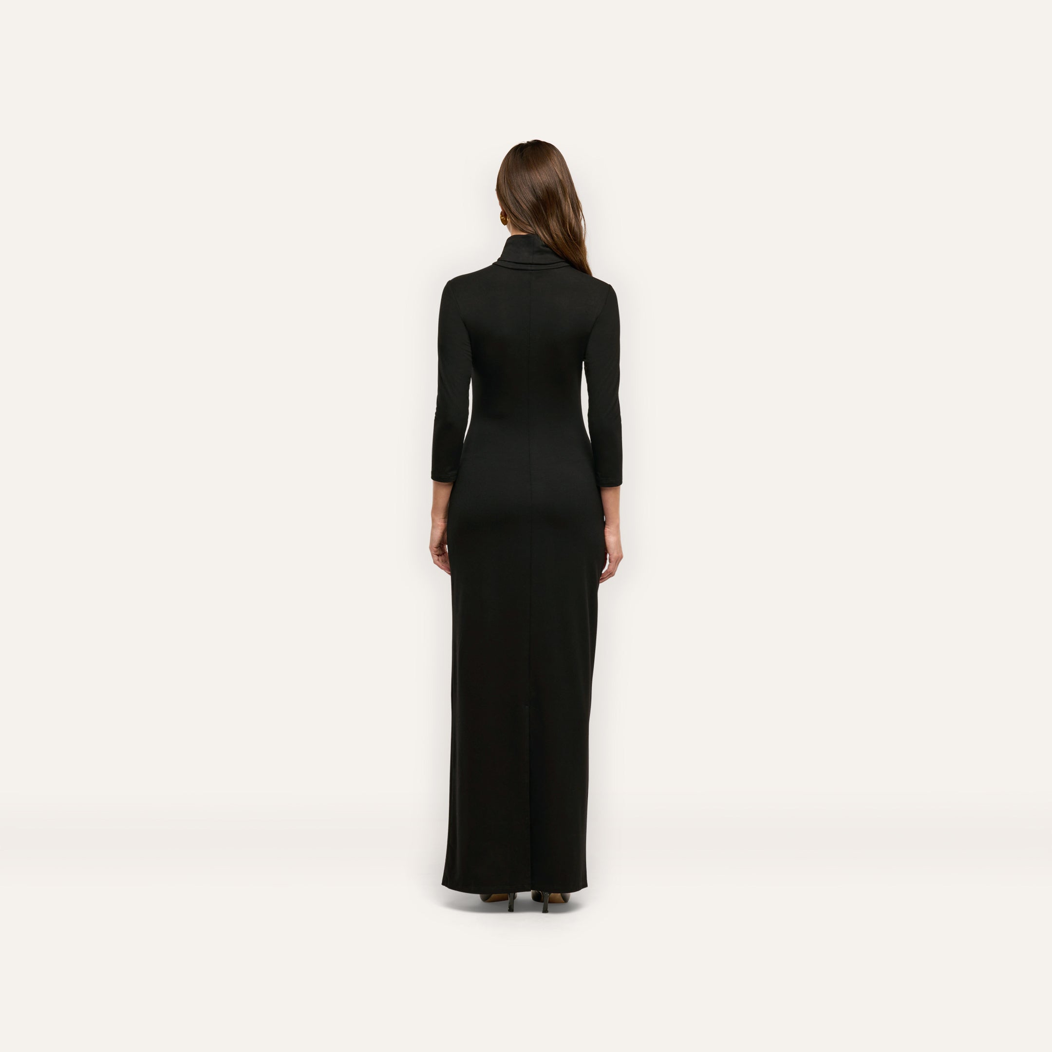Back view of a woman wearing the black, jersey knit Jaesyn Dress with a turtleneck and three-quarter length sleeves.