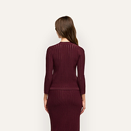 Back view of a person wearing a burgundy Irvin Pointelle Knit Cardigan and matching ribbed midi skirt, serving as a lightweight transitional layer.