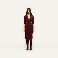 A woman wears a dark red, button-down Melania Pointelle Knit Skirt and a matching long-sleeved top with gold buttons, paired with brown knee-high boots and sunglasses.