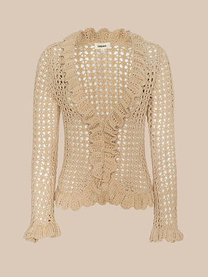 The Solaris Crocheted Cardigan is a beige, lightweight layer with an open-stitch pattern, long sleeves, and scalloped ruffle trim along the neckline, front, cuffs, and hem. Displayed against a neutral background.