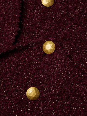 Close-up of the Bethany Knit Blazer by L'AGENCE: textured dark maroon knit with gold glitter and round faceted gold buttons set diagonally—a stunning, figure-flattering design.