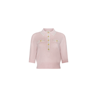 The Masaki Cropped Sweater is a light pink, featherweight knit polo top with three-quarter sleeves, white trim on the collar and placket, and gold buttons adorning the front and two chest pockets. Displayed against a plain white background.