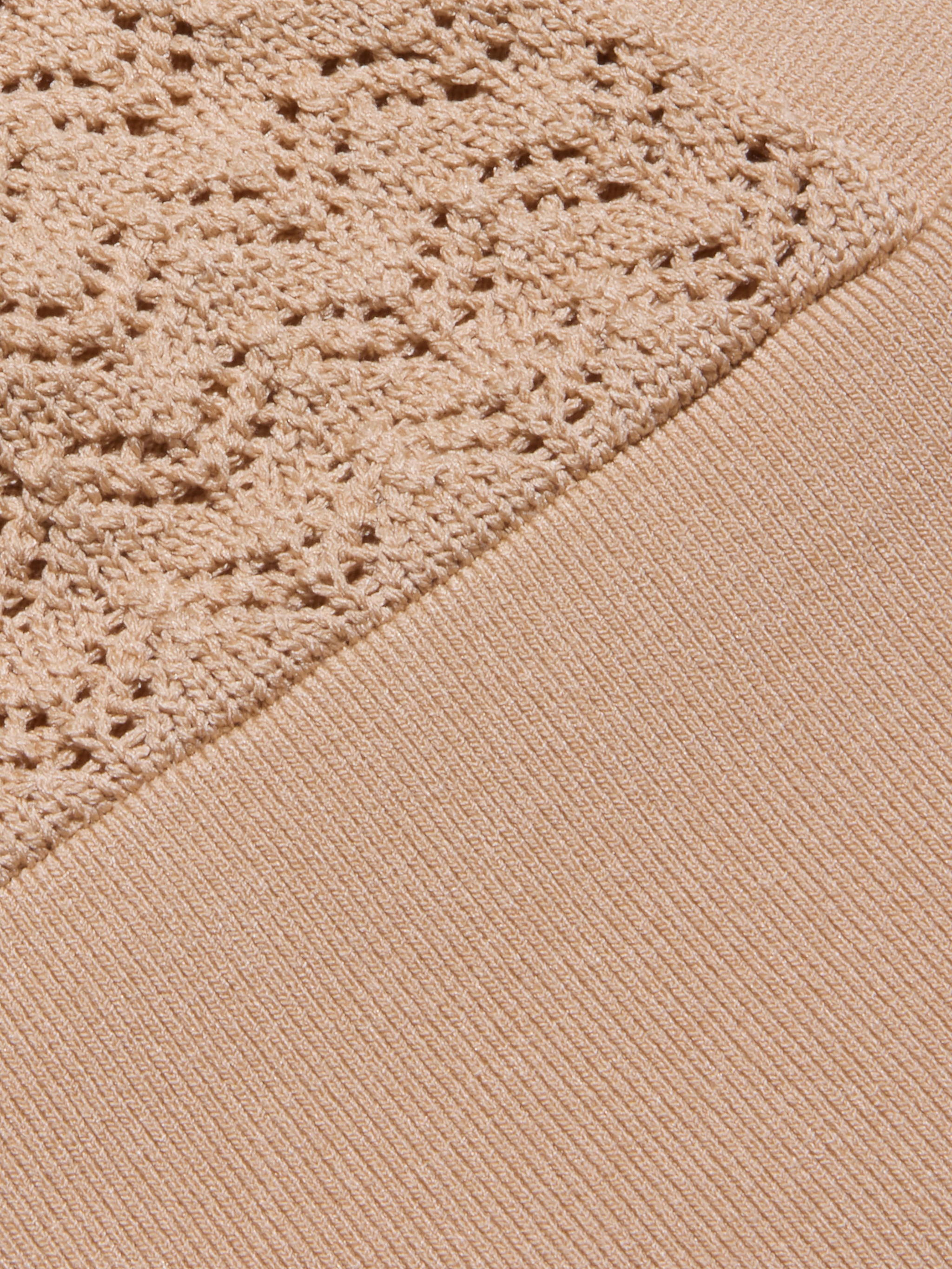 Detalle del Reverie Pointelle Knit Bralette en marrón claro, con dos texturas: un diseño de canalé en la parte inferior derecha y un delicado punto de pointelle en la parte superior izquierda, unido en diagonal a través del tejido.
