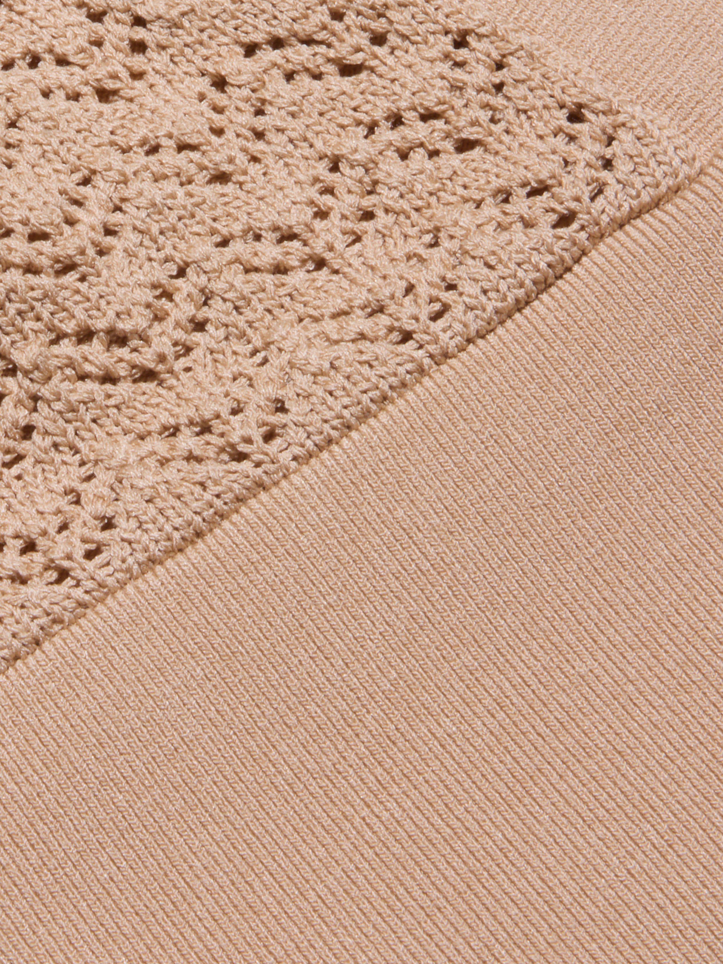 Detalle del Reverie Pointelle Knit Bralette en marrón claro, con dos texturas: un diseño de canalé en la parte inferior derecha y un delicado punto de pointelle en la parte superior izquierda, unido en diagonal a través del tejido.