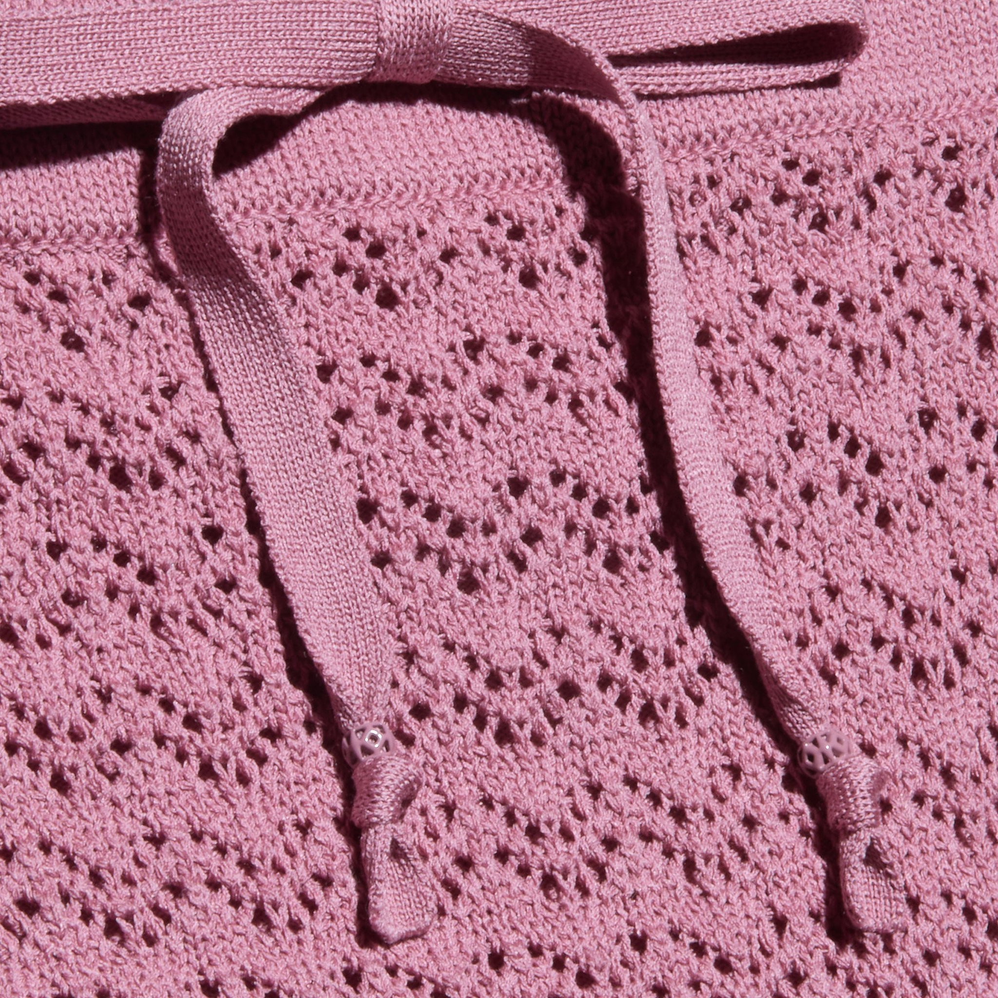 Primo piano della gonna Lacen Pointelle Knit in rosa, caratterizzata da un tessuto a maglia traspirante con un motivo a pizzo e due coulisse piatte sulla parte superiore.