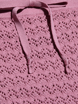 Close-up of the Lacen Pointelle Knit Skirt in pink, featuring breathable knit fabric with a lacy textured pattern and two flat drawstrings on top.