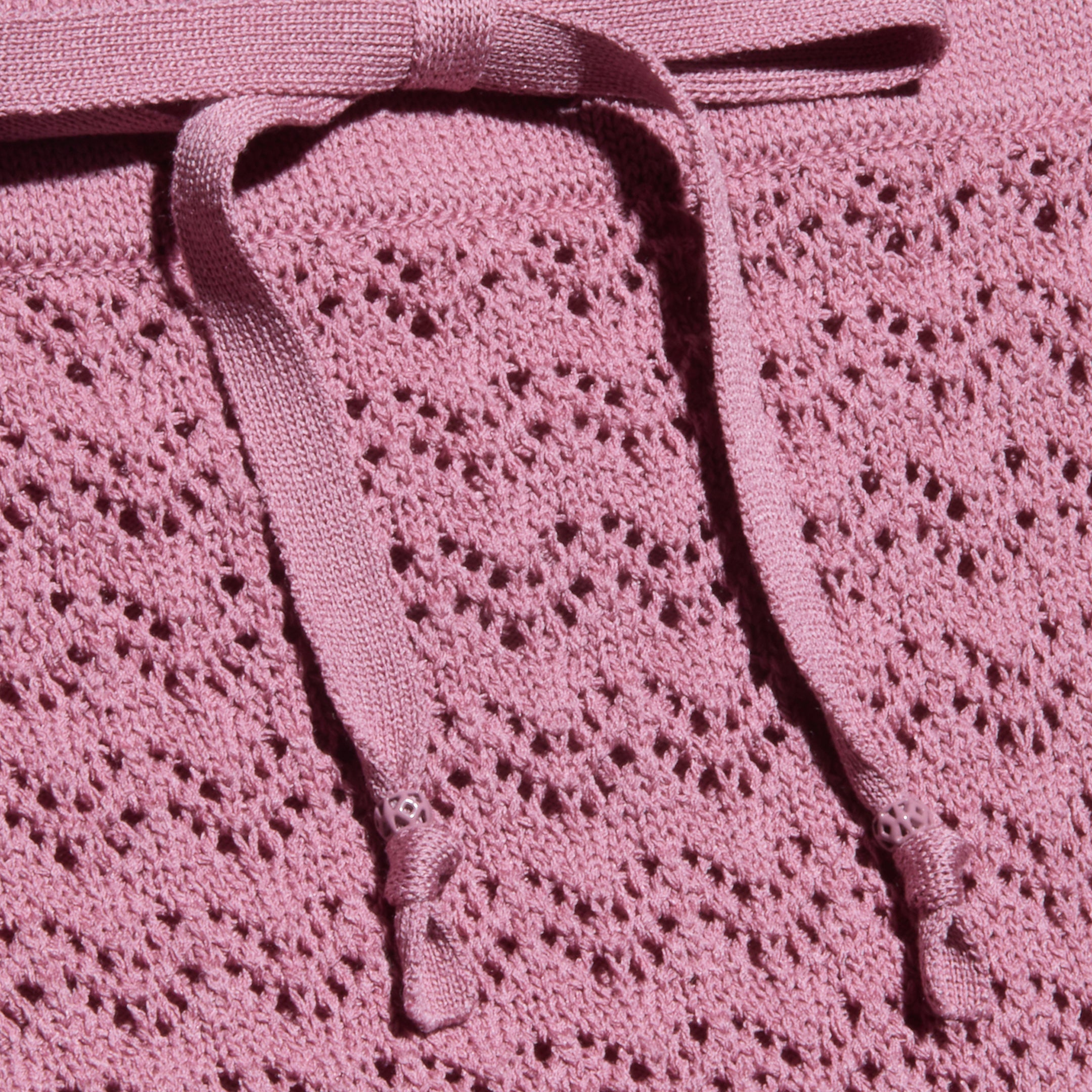 Primo piano della gonna Lacen Pointelle Knit in rosa, caratterizzata da un tessuto a maglia traspirante con un motivo a pizzo e due coulisse piatte sulla parte superiore.
