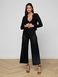 A woman stands against a plain light background wearing the Orla Pointelle Knit Cardigan paired with matching wide-leg pants and black high-heeled sandals.