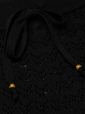 Close-up of the Gaelle Pointelle Knit Pant’s black pointelle knit fabric with a textured pattern and a lightweight black drawstring tied in a bow, finished with small gold decorative tips.