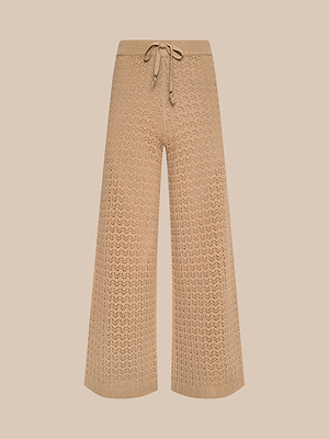 يتميز بنطال Gaelle Pointelle Knit بتصميم بيج واسع الساقين مع رباط خصر برباط، وهو مثالي للارتداء في العطلات الخفيفة، ويظهر على خلفية باللون البيج الفاتح.